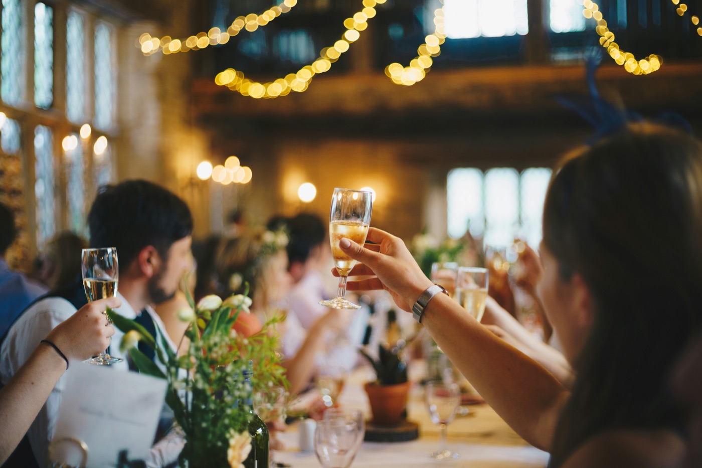 Guests raising champagne glasses at a candlelit celebration