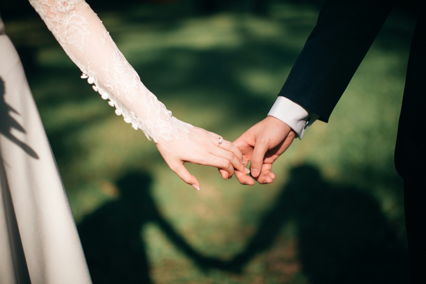 A bride and groom holding hands in the garden